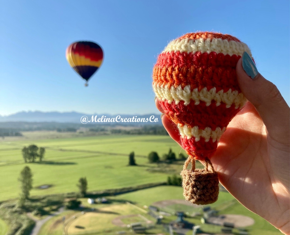 Crochet hot air balloon in front of real one